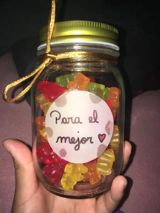 Frasco con caramelos - Materiales: Un frasco de vidrio, una cinta y una hoja y cinta adhesiva (para hacerlo más económico). En el frasco pones los caramelos, chocolates o chicles que le gusten a tu novios, luego haces un moño con la cinta una vez que la pongas en el frasco. En la hoja puedes escribirle un mensaje, o corazones y luego pones la cinta por encima, pero si quieres que se pegue mejor le puedes poner silicona fría.