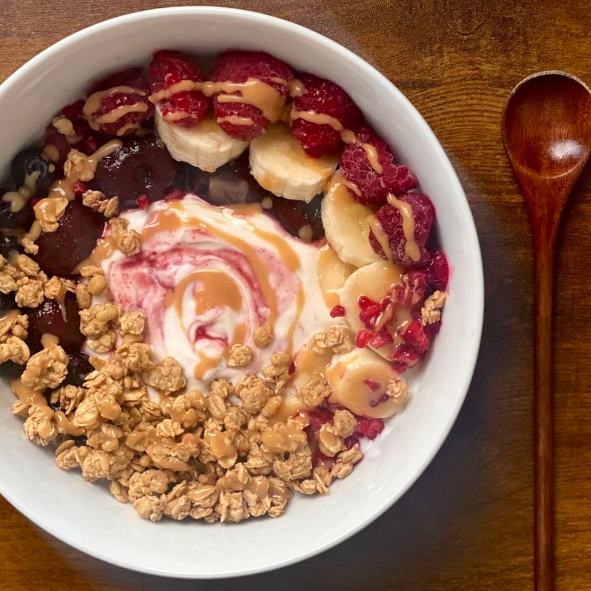 Greek yoghurt with toppings - granola, banana, peanut butter, berries, honey, cinnamon, crushed nuts