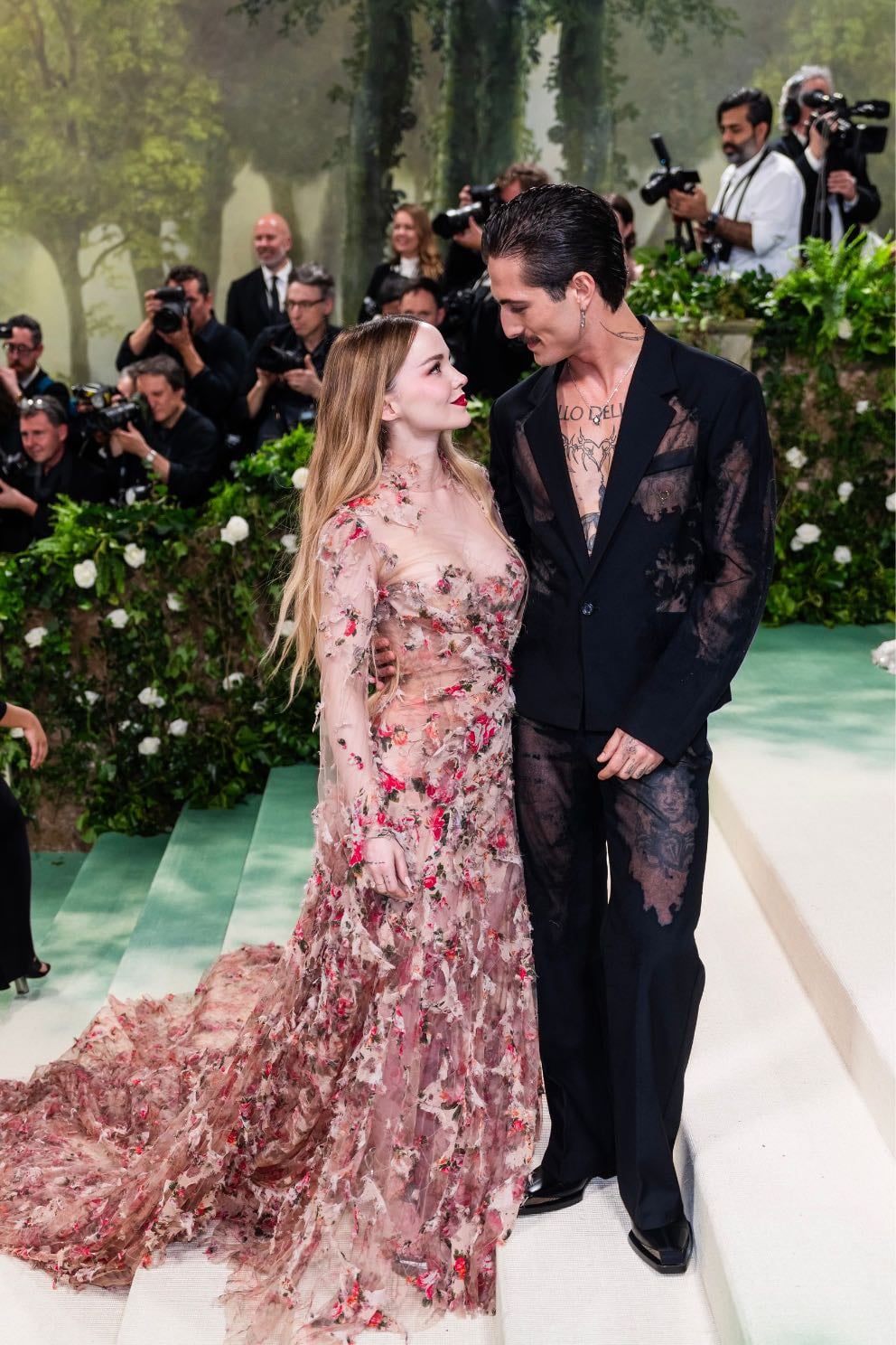 dove cameron + damiano david - custom diesel
both designed by glenn martens.
a victorian-era, floral-print, tulle and chiffon deconstructed gown.
semi-sheer black tuxedo made with a devoré technique.