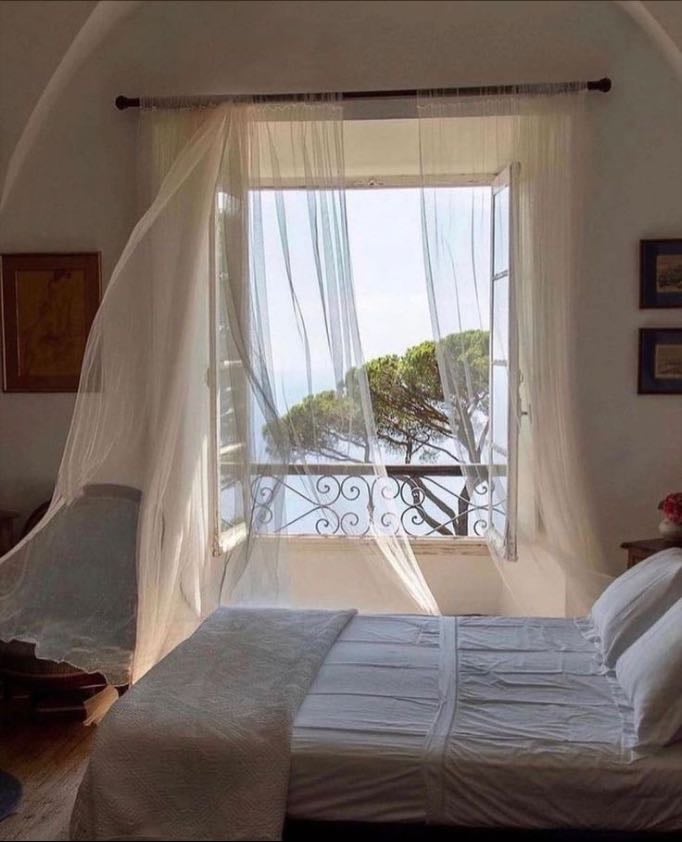 Watching thin curtains puff up with wind during summer