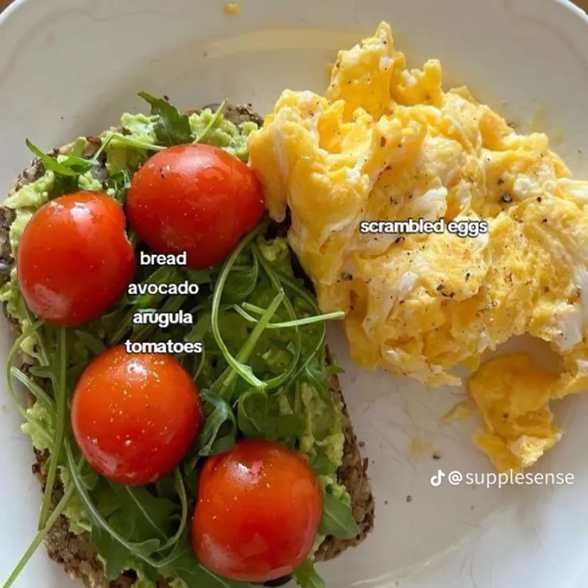 Tostadas de aguacate con tomates cherry , rugula y huevos revueltos