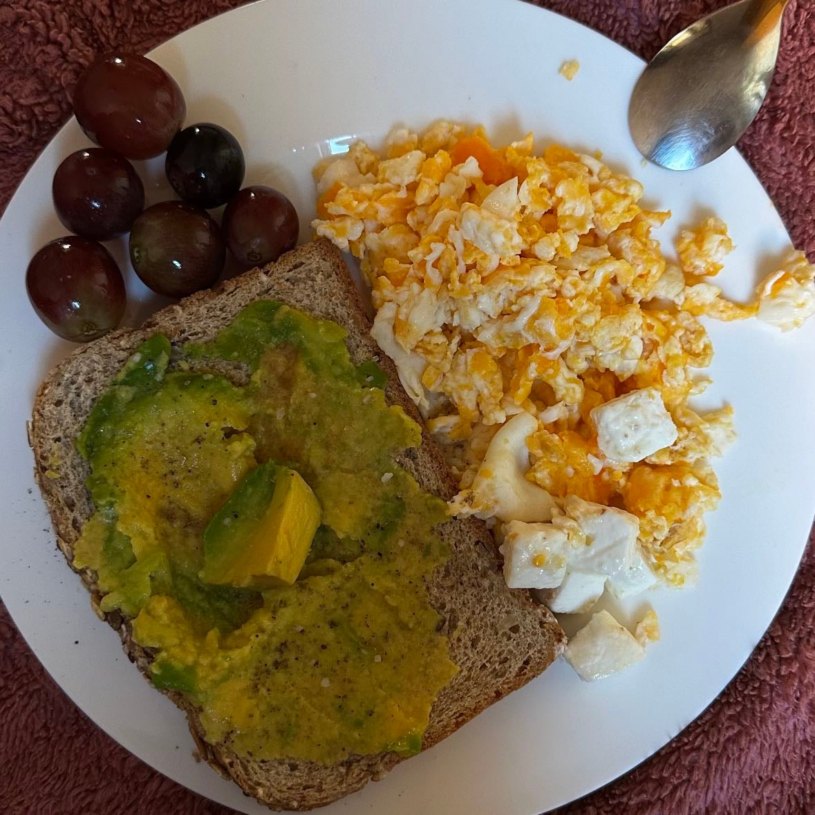 Desayuno - Pan tostado con aguacate, huevos revueltos con queso feta y uvas