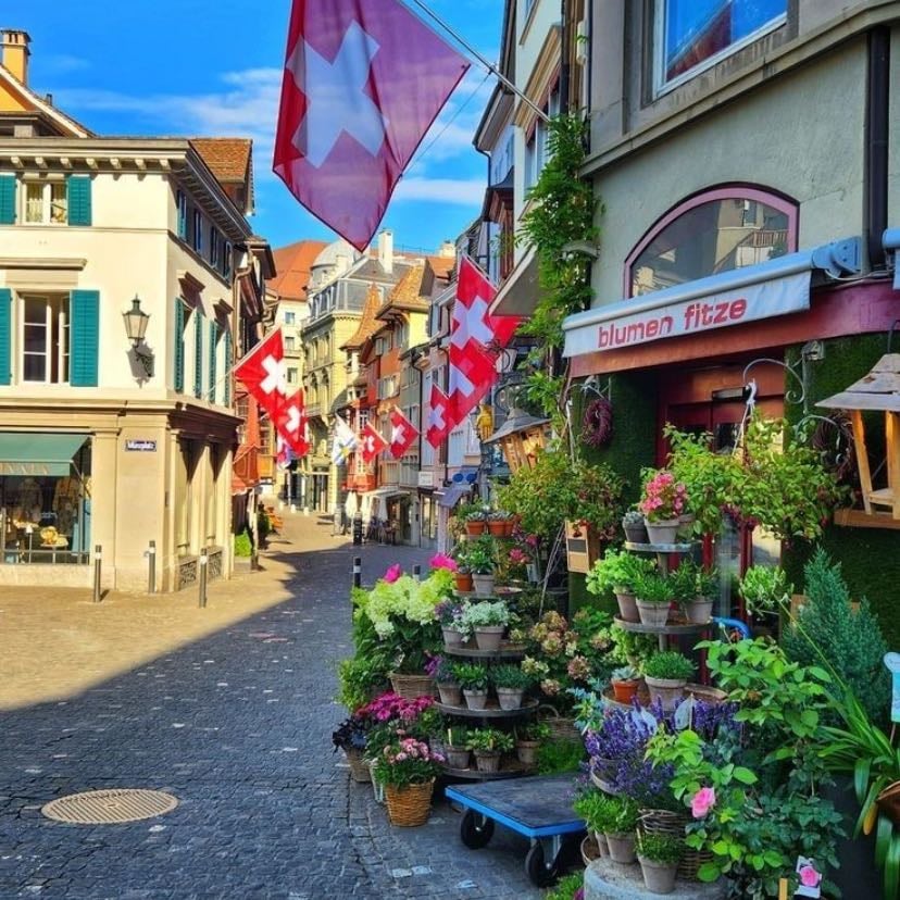 SUIZA 🇨🇭 - Suiza es un país montañoso de Europa Central, con varios lagos, aldeas y las altas cimas de los Alpes. Sus ciudades tienen barrios medievales, con monumentos como la torre del reloj Zytlogge en su capital, Berna, y el puente de madera de la capilla en Lucerna. El país también es famoso por sus centros de esquí y los senderos de excursionismo. Las industrias bancaria y financiera son clave, y los relojes y el chocolate de Suiza son conocidos en todo el mundo.