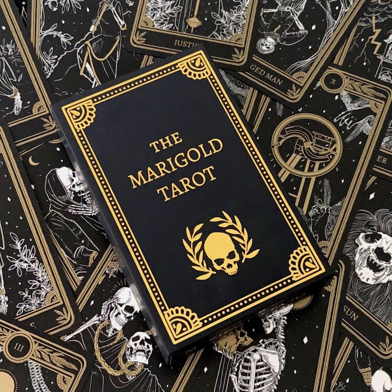 The Marigold Tarot - Estética sombria com ilustrações esqueléticas douradas | Dark aesthetics with golden skeletal illustrations.