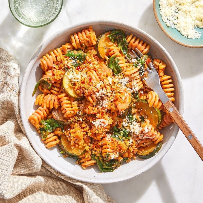 whole grain noodles with tomato-zucchini-sauce - 70-80g whole grain noodles (uncooked), 150ml strained tomatoes, 1/2 zucchini, 1 garlic clove, 1/2 onion, basil, oregano, 1 tsp olive oil, (optional: 1 tsp parmesan)