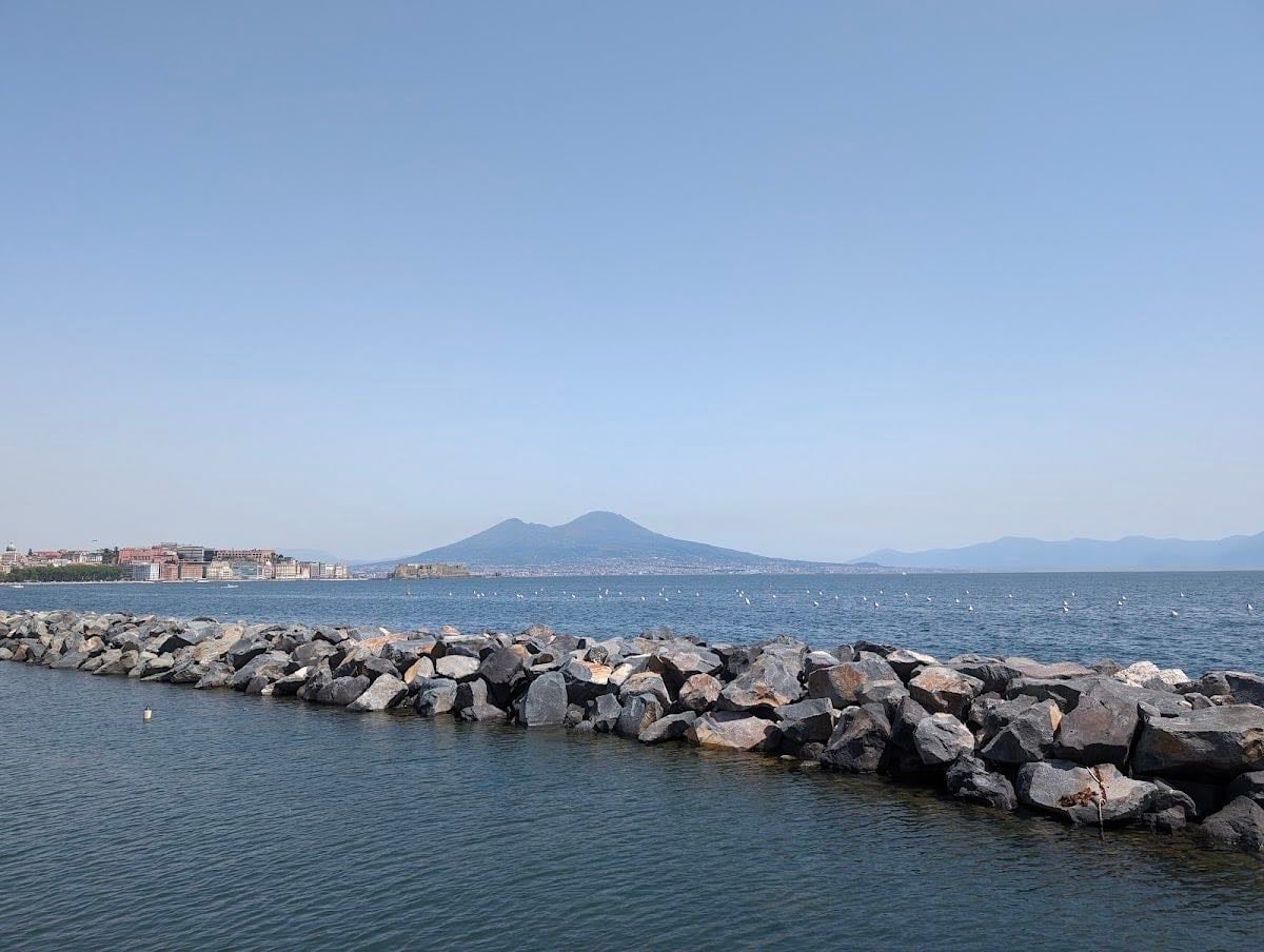 Via Francesco Caracciolo - The waterfront promenade with views of the Bay of Naples and Mount Vesuvius — both present in the background of the novels.