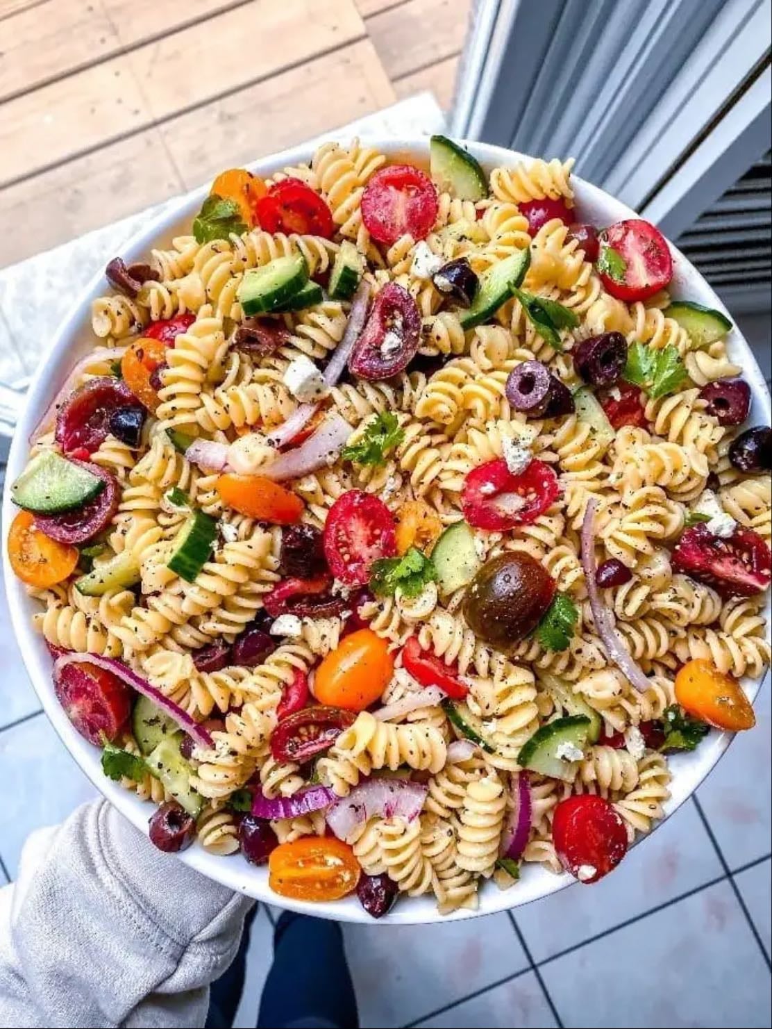 Salade de pâte à la grec - mélange des pâtes avec tomates, concombre, olives, oignons rouge et fêta. Huile d’olive, jus de citron et origans.