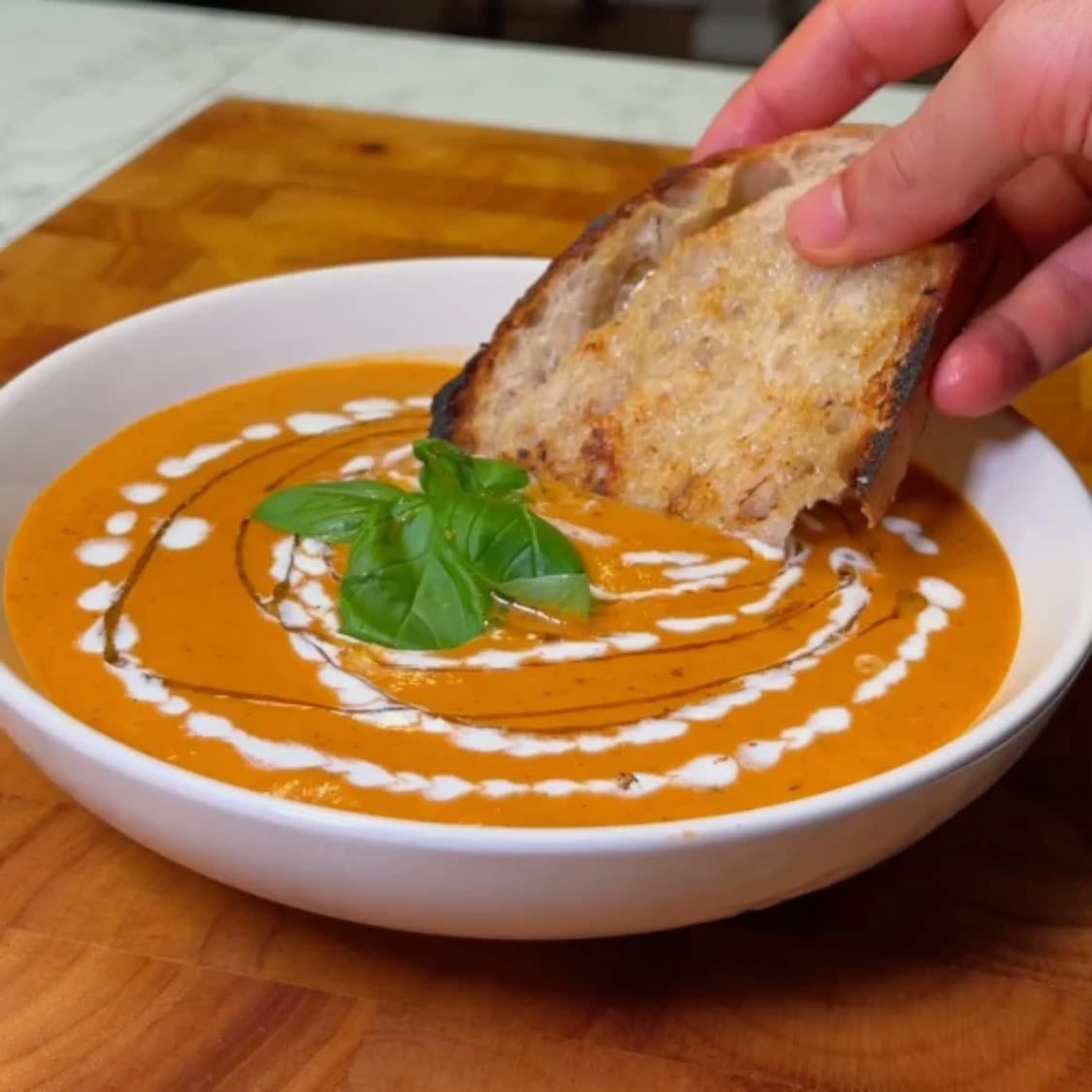 Crème de tomates et poivrons rotis - 1 kg tomates au choix à propos de livres 2.2 3 poivrons rouges environ 450 g / 1 livre, épépinés et coupés en quartiers 2 oignons coupé en quartiers ou en deux 2 têtes d'ail 45 ml huile d'olive extra vierge divisé (3 cuillères à soupe) 1 càc assaisonnement italien 1 Pinch poivre de Cayenne facultatif Sel fin et poivre noir fraîchement moulu goûter 480-720 ml bouillon de légumes 2-3 tasses 240 ml crème d'avoine ou crème de coco entière 1 tasses Huile d'olive supplémentaire et pain au levain pour la garniture Préparez les légumes : Préchauffez votre four à 200°C (400°F). Placez les tomates, les poivrons rouges et les oignons sur une plaque de cuisson. Arrosez de 30 ml (2 cuillères à soupe) d'huile d'olive, saupoudrez d'assaisonnement italien, de poivre de Cayenne (si vous en utilisez), de sel et de poivre. Rôtir l'ail : Couper le haut des têtes d'ail, les placer sur la plaque de cuisson avec les légumes. Faire rôtir les légumes : Faire rôtir les légumes et l'ail au four pendant 40 à 50 minutes, jusqu'à ce qu'ils soient tendres et légèrement carbonisés. Vérifier à mi-cuisson et remuer si nécessaire. L'ail doit être mou lorsque vous le pressez. Mixez la soupe : Une fois rôtis, transférez délicatement les légumes dans un mixeur. Pressez les gousses d'ail rôties pour les extraire de leur peau et versez-les dans le mixeur. Ajoutez 480 à 720 ml (2 à 3 tasses) de bouillon de légumes. Mixez jusqu'à obtenir une consistance lisse. Laisser mijoter la soupe : Verser le mélange mixé dans une casserole à feu moyen. Incorporer 240 ml (1 tasse) de crème d'avoine ou de crème de coco et porter à ébullition. Goûter et rectifier l'assaisonnement avec du sel et du poivre si nécessaire. Servir et garnir : Verser la soupe dans des bols. Garnir d'un filet de crème supplémentaire, d'huile d'olive et servir avec des tranches de pain au levain grillées.