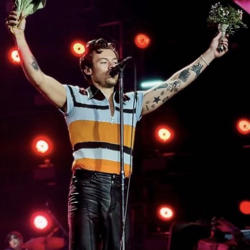 munich 05/16/2023 - black, light blue, and orange striped quarter-zip shirt, black leather pants, brown satellite stompers