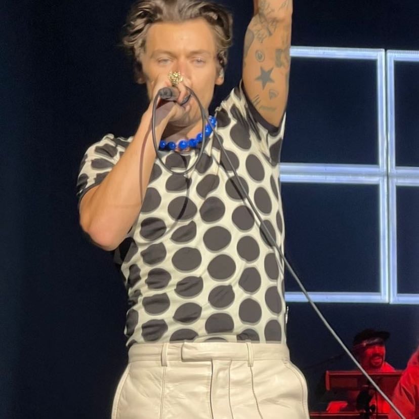 london 05/24/2022 - white and black polka dotted tee, white pants, blue ball necklace, green and white satellite stompers