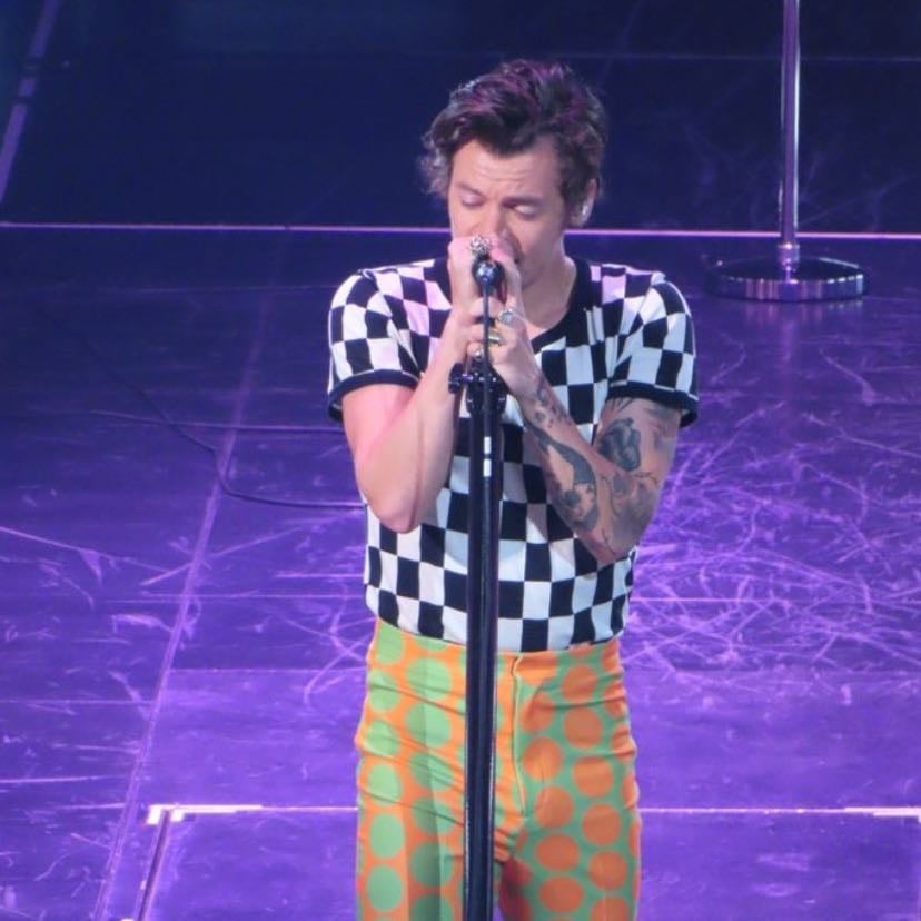 austin 09/26/2022 - black and white checkered tee, orange and green split pants with green and orange polka dots, green satellite stompers