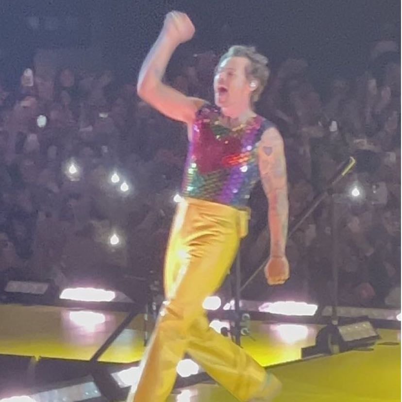 la 10/26/2022 - rainbow sequin shirt with red heart sequins in middle, yellow pants, yellow and magenta satellite stompers