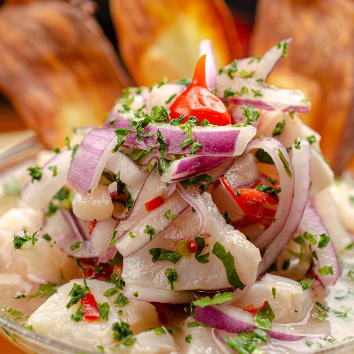 Ceviche Peruano - Pescado crudo marinado en jugo de lima, con cebolla, cilantro y ají