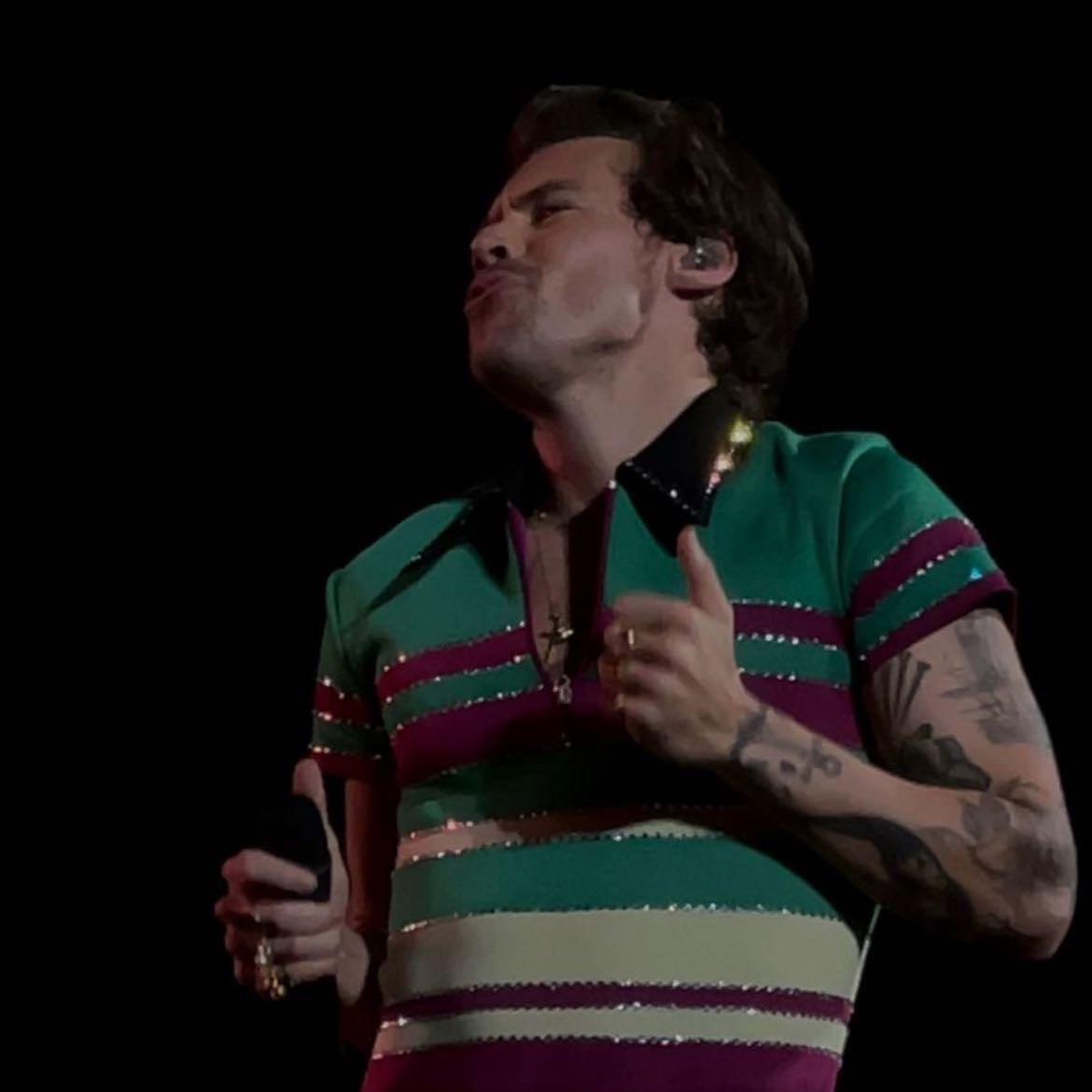 singapore 03/17/2023 - Black leather pants, light yellow, green, purple and red quarter zip T-shirt with rhinestones, purple satellite stompers