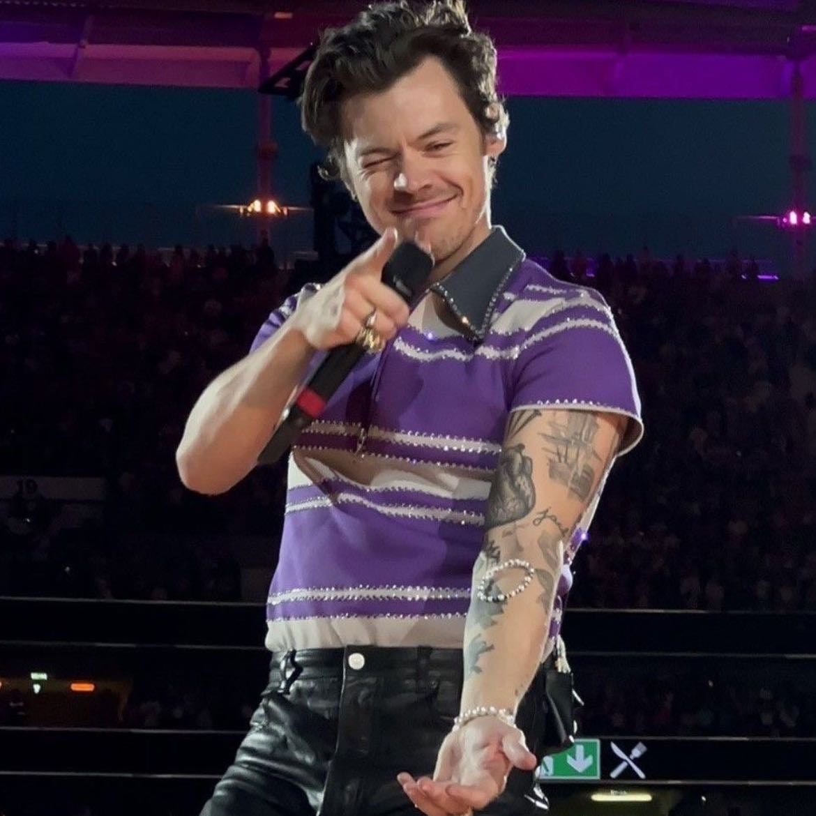 frankfurt 07/06/2023 - Black leather pants, purple and grey striped quarter zip T-shirt with a bit of glitter, purple satellite stompers