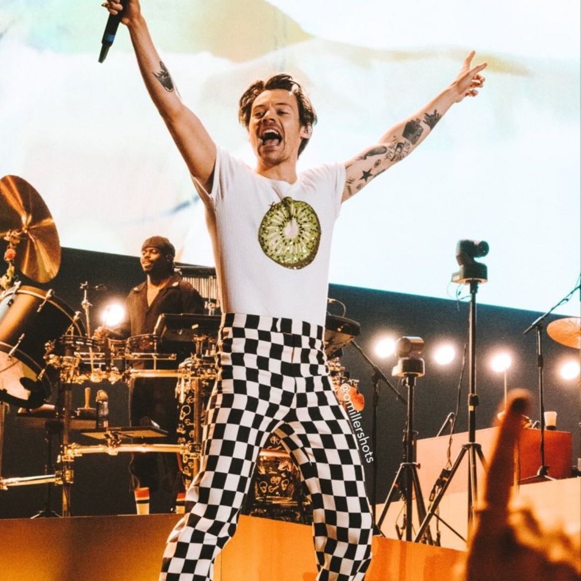 vienna 07/16/2022 - Black and white checkered leather pants, white T-shirt with kiwi, red satellite stompers