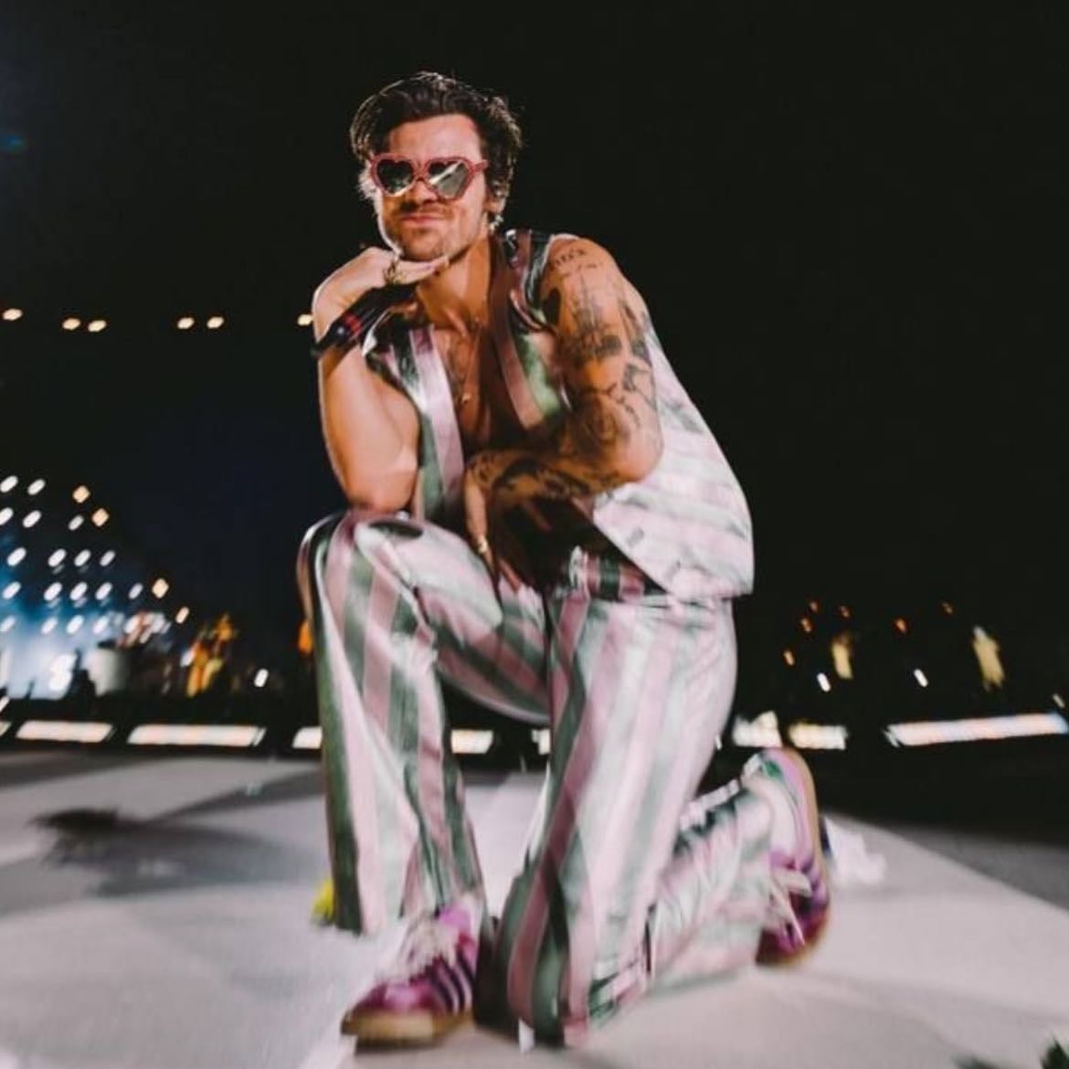 madrid 07/14/2022 - Loose pants with metallic green and pink stripes, no shirt, vest with metallic green and pink stripes, pink and purple satellite stompers