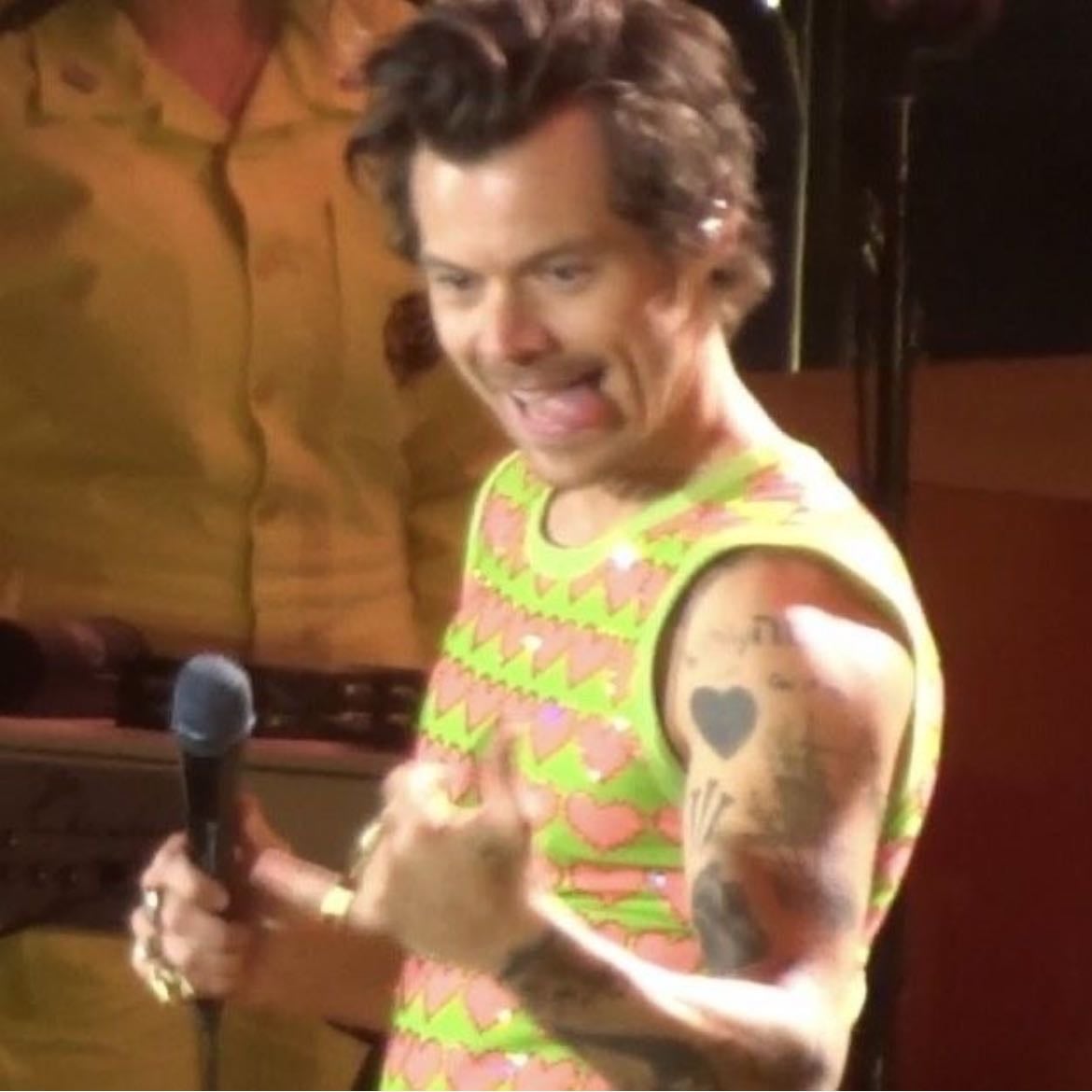 santiago 12/01/2022 - Beige leather pants, neon green tank top with pink hearts with rhinestones around, dark green satellite stompers