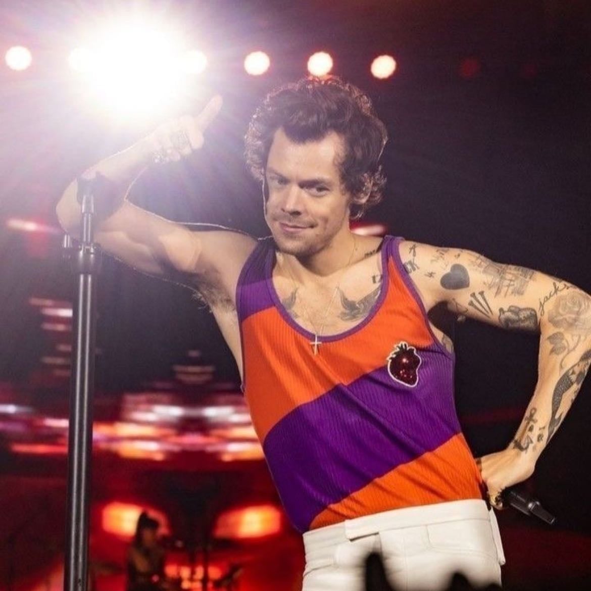 buenos aires 12/04/2023 - White leather pants, orange and purple striped tank top with glittery strawberry on the front, red satellite stompers
