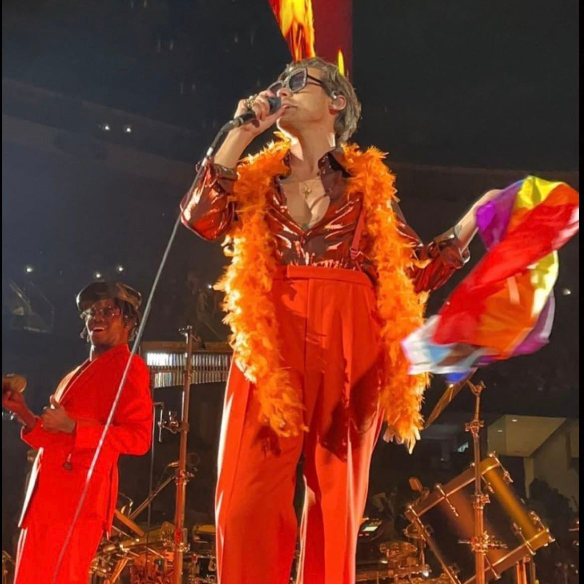 st louis 09/15/2021 - Orange loose pants, orange suspenders, orange metallic long-sleeve button up, white boots