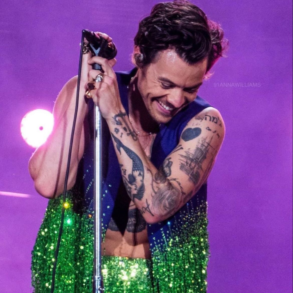 vienna 07/08/2023 - Green loose tinselled and glittery pants, no shirt, purple vest with green sparkly tinsels, purple satellite stompers