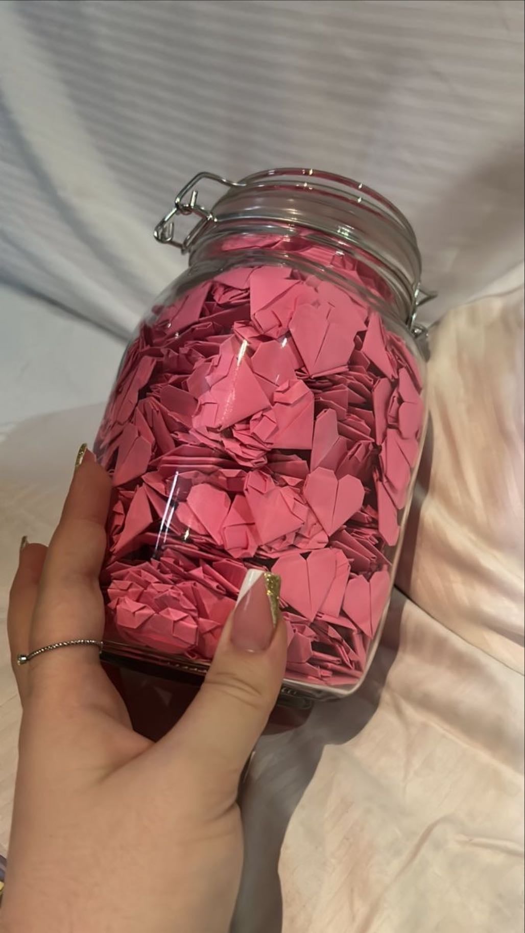 A jar filled with hundreds of origami paper hearts
