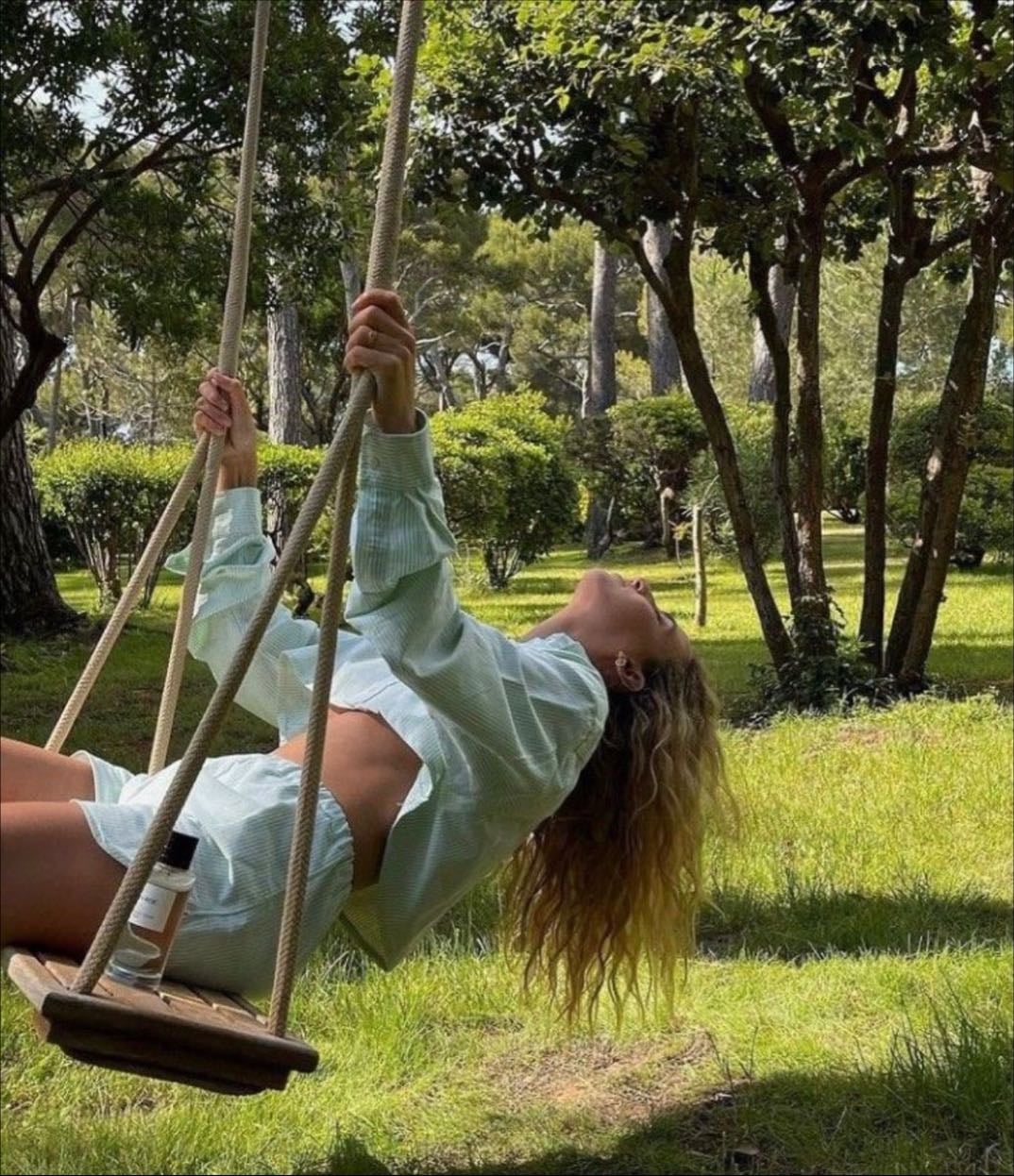 Laying back on a rope swing in a dreamy garden