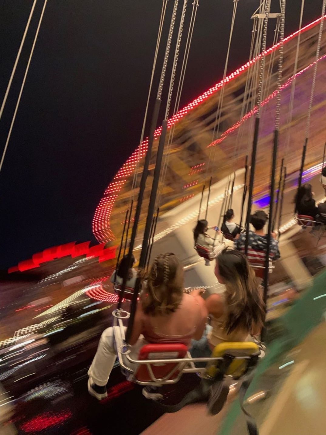 Swing carousel ride at night with all the lights blurred